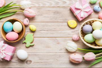 Easter frame with eggs, gift box and tulip on a colored background. The minimal concept. Top view Happy Easter composition. Card with a copy space of the place for the text