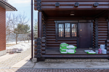 preparation for the new planting season: bags of soil for seedlings lie on the porch of a log house. High quality photo