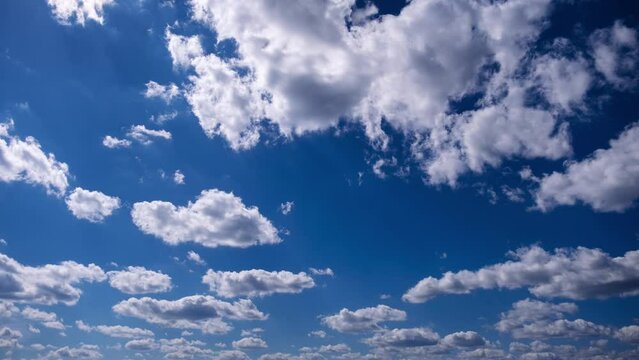 Timelapse of cumulus clouds moves in the blue sky. The background of light and heavy calm clouds changes shape in cloudy space. Natural background, time-lapse, copy space. 4K.