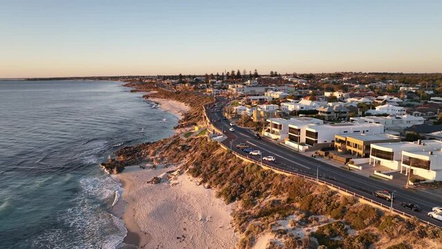 Coastal drive at sunset golden hour. Beaches with cars driving along Trigg in Perth Western Australia. Aerial drone footage filmed on the dji Mavic 3 drone in 4k