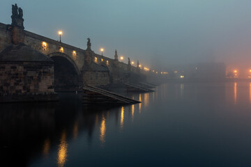 View of the Charles Bridge in Prague at the sunrise with mystical fog. Czech Republic.