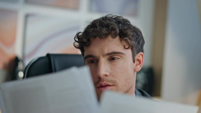 Closeup focused ceo reading contract papers desk. Pensive man thinking business