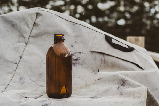 Old stubby beer bottle on barbecue cover