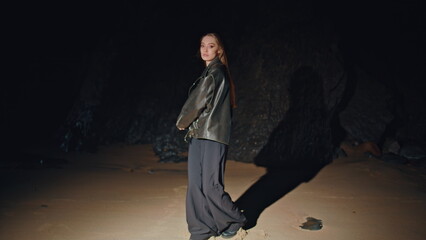 Fashion girl modeling beach in jacket at night zoom on. Woman spinning in dance