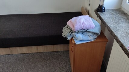 Unfolded bed in a student dormitory and dirty bed linen. Changing bed linen