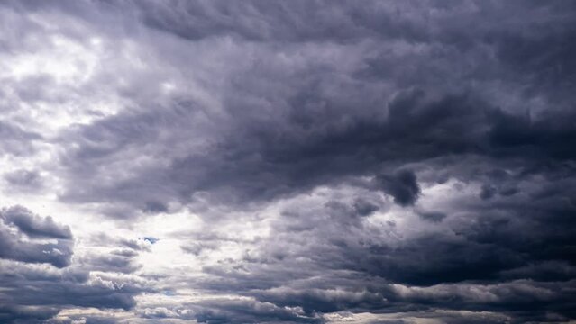 Storm clouds move in the sky, timelapse. Background of gray cumulus thick rain clouds in cloudy space. Time-lapse of dramatic sky. Change of weather. Natural background, copy space. 4K