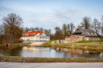 View of Berkenes Manor and agricultural buildings. Located in a picturesque place in early spring. Latvia, Baltic.
