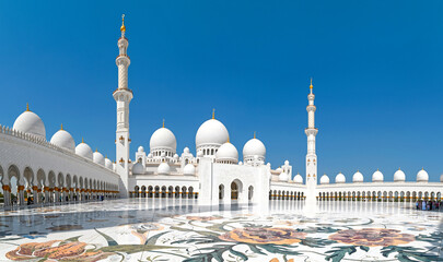 Panoramic view of amazing white Sheikh Zayed Grand Mosque during sunny day against blue sky in Abu Dhabi, United Arab Emirates