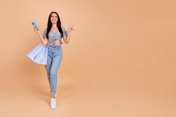 Fototapeta na wymiar Photo of stunning glamour lovely cheerful woman wear blue trendy spring clothes packages blank space isolated on beige color background