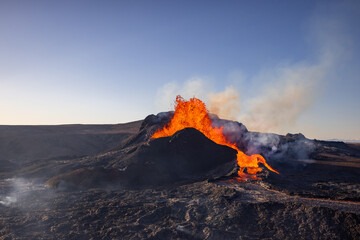 A volcano is spewing lava and flames into the sky from a fissure vent in the middle of a desert...