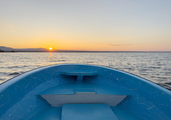 Blue boat bow on sunset background