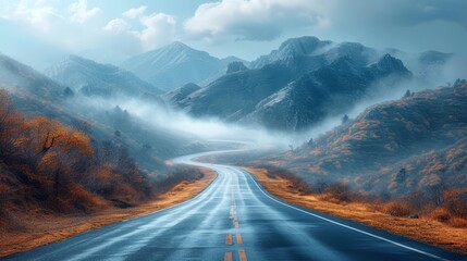   A long road winds through a mountain range, surrounded by foggy hills Mountains shrouded in mist form a backdrop - obrazy, fototapety, plakaty