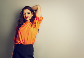 Beautiful relaxing happy casual woman in bright orange t-shirt looking on blue studio background on empty copy space. Closeup - 777508673