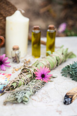 Obraz na płótnie Canvas Detail of two bundles of herbs and several jars of oils