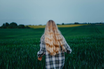 long-haired blonde woman in a field in summer, nostalgia and memories of summer.