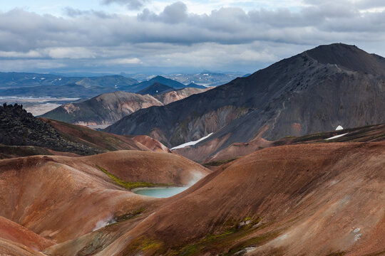 Landmannalaugar National Park. Colorful slopes of the rhyolite mountains with lake. Iceland adventure hiking Laugavegur trail to Landmannalaugar.