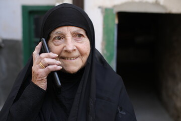 Cheerful senior muslim woman making a phone call 