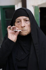 Senior Islamic woman smoking a cigarette 