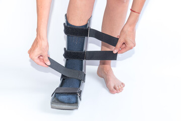Woman Putting on a Walking Boot for Foot Sprain or Fracture