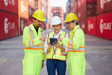 workers working on tablet for checking product in containers warehouse storage