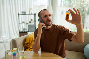 Anxious man calling his doctor to ask what pills to take