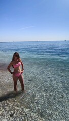 Fototapeta premium Brunette woman with long hair and sunglasses on the beach shore. Mediterranean Sea, Benalmadena, Malaga, Andalusia, Spain. Summer time