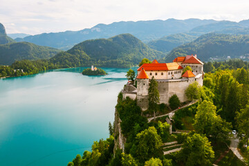 Fototapeta na wymiar Aerial view of mediaeval Bled castle on the cliff of the mountain under lake Bled with turquoise blue water in Slovenia