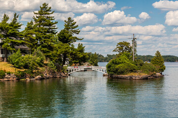 A view in Ontario, Canada of the Thousand Islands with cottage on the river, bridge and the surrounding nature on a summer afternoon