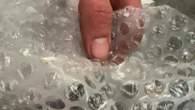 Video of a hand popping bubble wrap