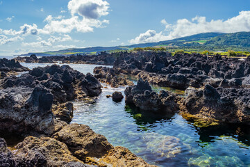 Transparent natural sea pools in Biscoitos with mountain in the background, Terceira - Azores PORTUGAL