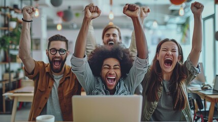 happy diverse successful business team celebrating a triumph with arms up in startup office. multiethnic business group with laptop screaming and holding fists up