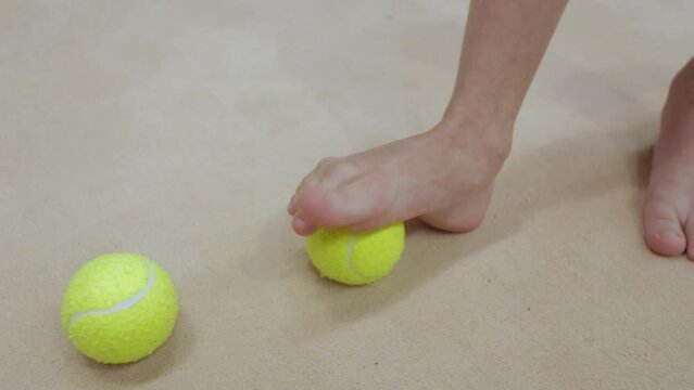exercise with a tennis ball for the foot