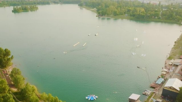 Aerial drone view of wake lake. Wake boarding on beautiful blue lake lear city on sunny summer day. (4K)