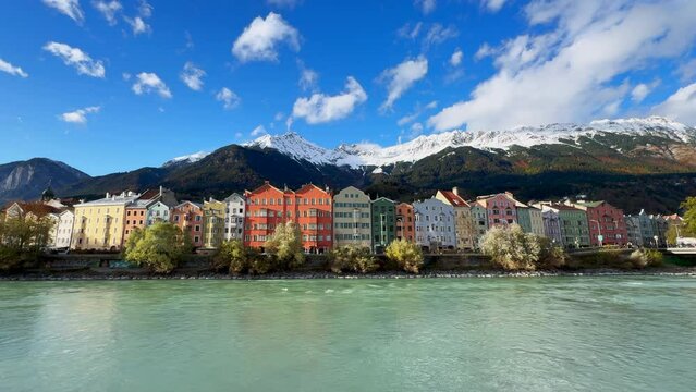 Innsbruck Austria colorful pastel buildings capital Tyrol Tyrolean Alps mountain backdrop the bridge over the Inn River Innbr&uuml;cke clear blue sky clouds October November autumn fall wide static shot