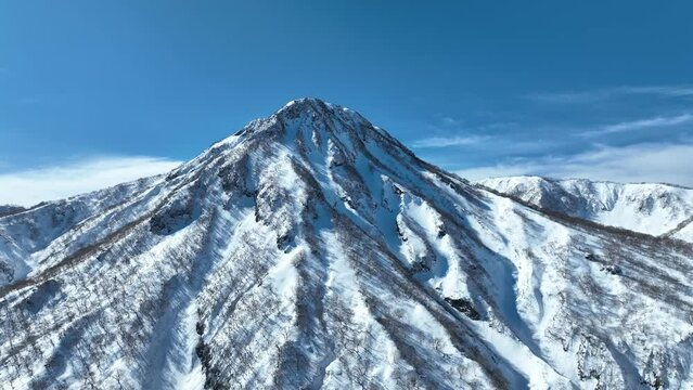 Aerial wide shot orbiting mountain Japan mount myōkō, on a clear winter day, a volcanic mountain in Myoko-Togakushi Renzan National Park region