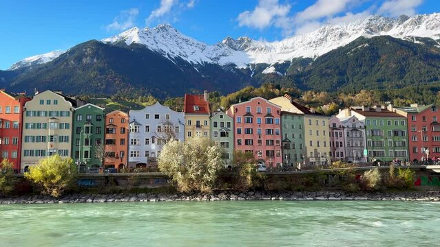 Innsbruck Austria colorful pastel buildings capital Tyrol Tyrolean Alps mountain backdrop the bridge over the Inn River Innbr&uuml;cke clear blue sky clouds October November autumn fall sunny static shot