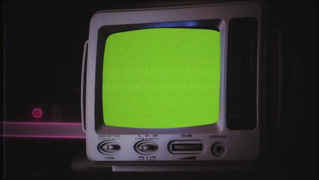 Retro TV Radio Green Screen Old Compact Television VHS Texture, Zoom In. Vintage compact television radio with green screen, for replacement, on a table, old VHS Effect. Zoom in