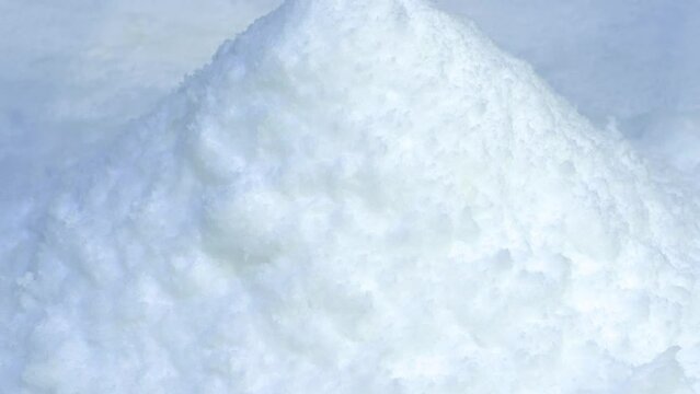 Snow from snow generator. Pile of snow, white snowdrift. Ice flake making machine. Snow making machine produce artificial snow. Snow falls from snowmaking apparatus. Snow production technology