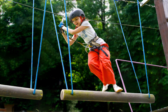 adventure climbing high wire park - people on course in mountain helmet