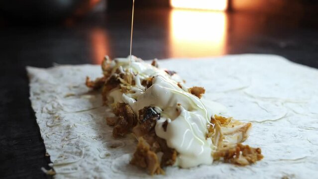 A cook cuts meat to make shawarma