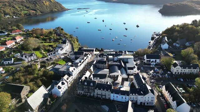 Drone shot of the small Scottish town of Portree, Isle of Skye, with some boats in the waters.