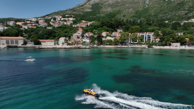 Shot of a motorboat ride on the sea with Dubrovnik in the background.