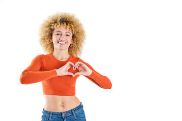 young girl with blonde afro hair smiling making heart shape with hands on white background