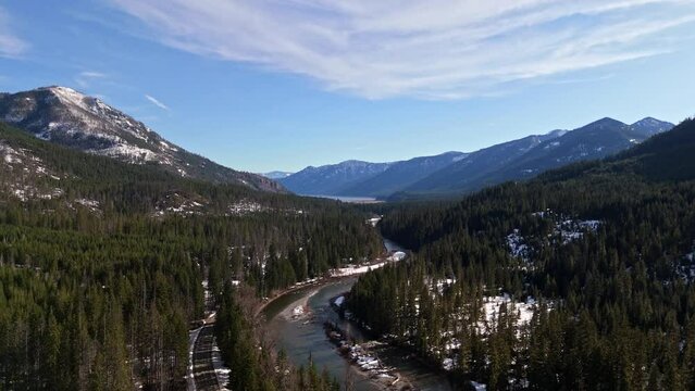 Scenic view of river, forest, and mountain range in background with snow in Cle Elum on a peaceful day in Washington State.
