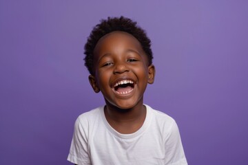 Joyful young Hispanic African boy on violet background