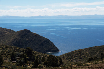 Blue immensity of Lake Titicaca and the sky contrasting with green hills on Isla Del Sol in Bolivia