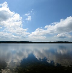 Serene waters of Lake Conroe reflecting the blue sky with white fluffy clouds
