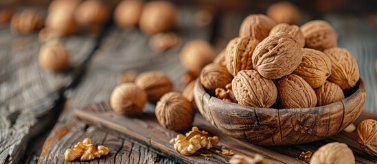 A wooden bowl filled with a variety of walnuts displayed on a wooden table. - obrazy, fototapety, plakaty