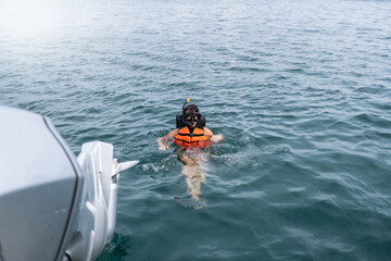 Man Swimming in Ocean With Life Jacket