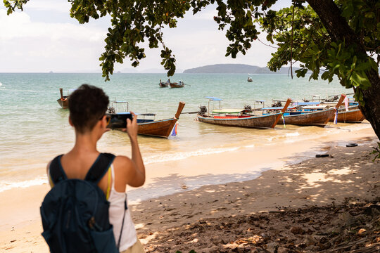 Woman Taking Picture of Boats on Beach